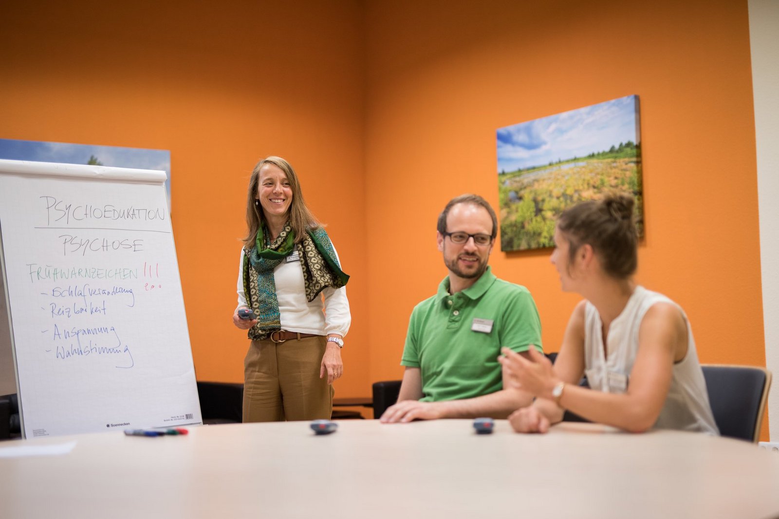 Dozentin am Flipchart mit zwei Teilnehmern