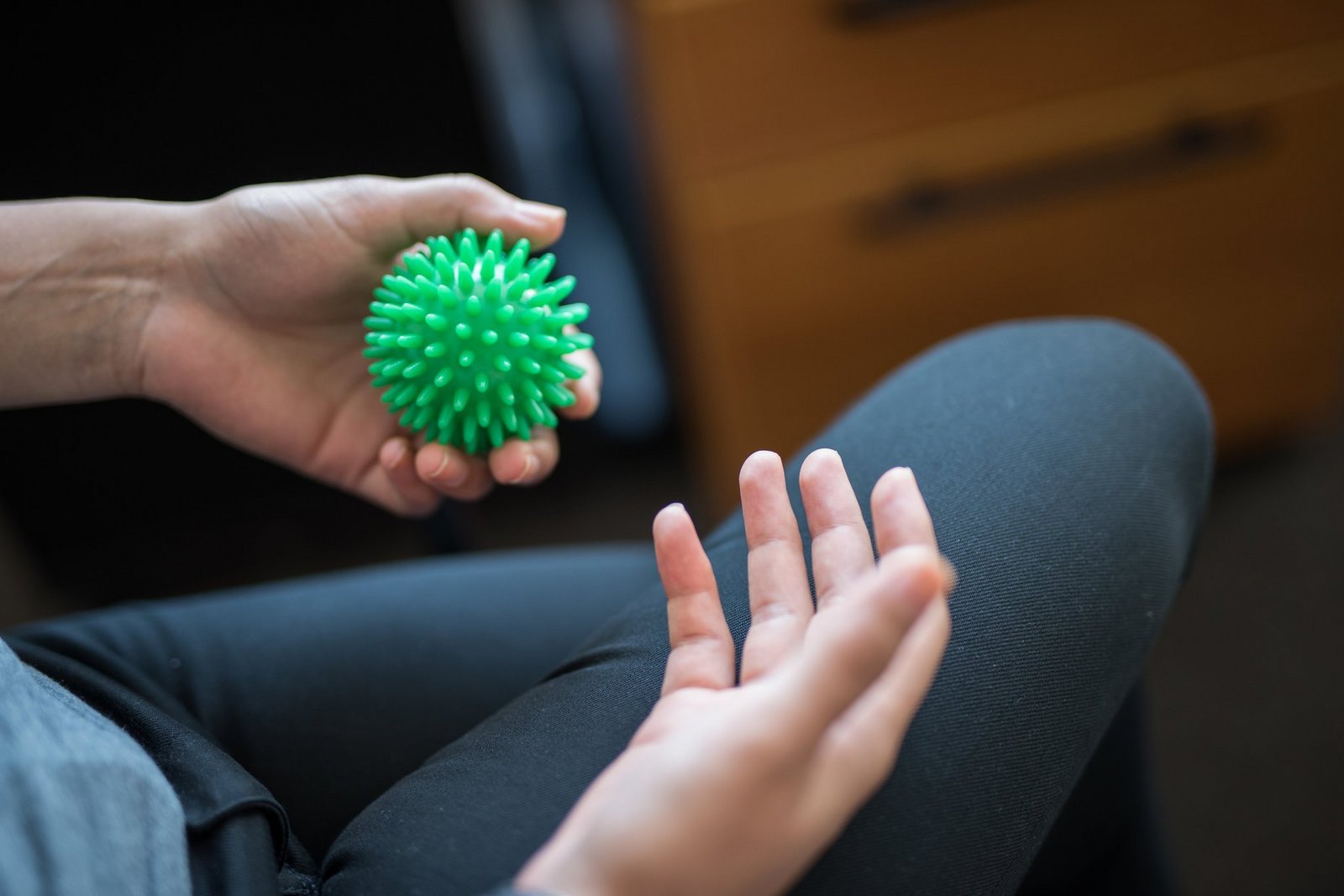 Eine Hand gibt einen Massageball weiter